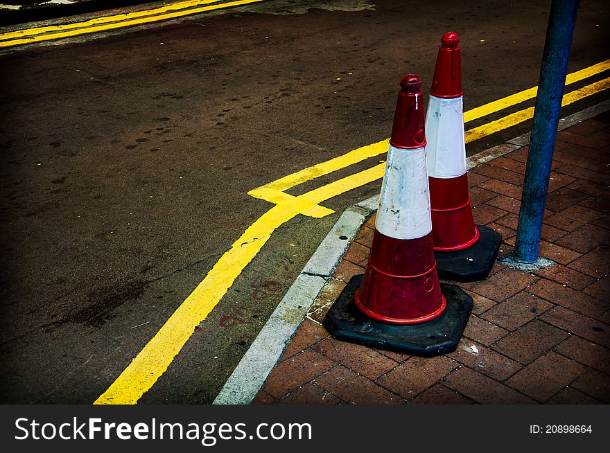 Twin of traffic cones on pavement