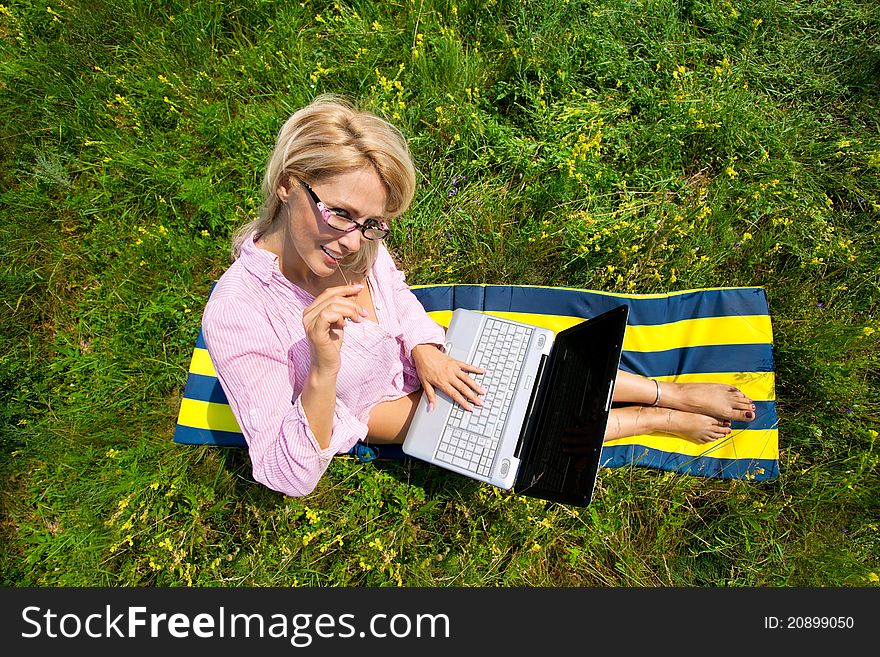 Top view of woman with laptop sitting on blanket