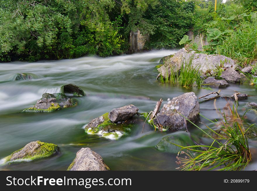 Flow water in river. Speed, summer, stone.