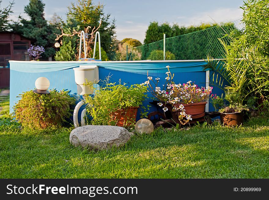 Swimming pool in a garden during the sunset time.