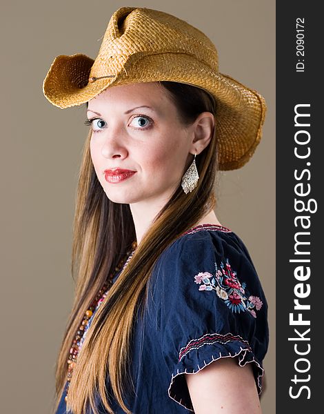 An attractive young brunette woman in a western outfit. An attractive young brunette woman in a western outfit