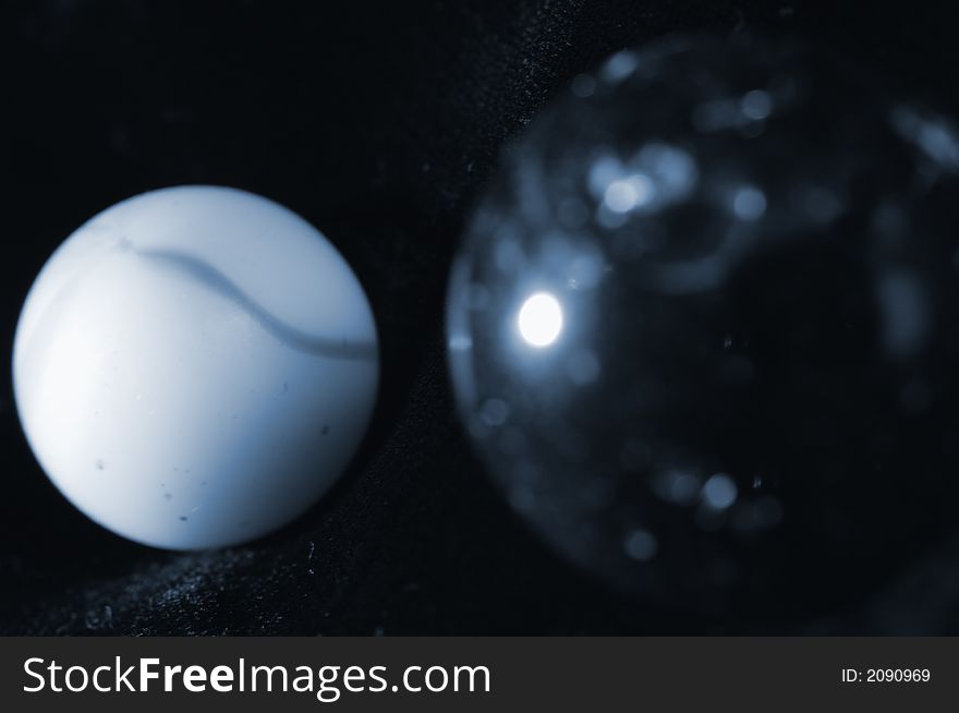 Two glass-balls against black, planet concept in a bluish tone. Two glass-balls against black, planet concept in a bluish tone