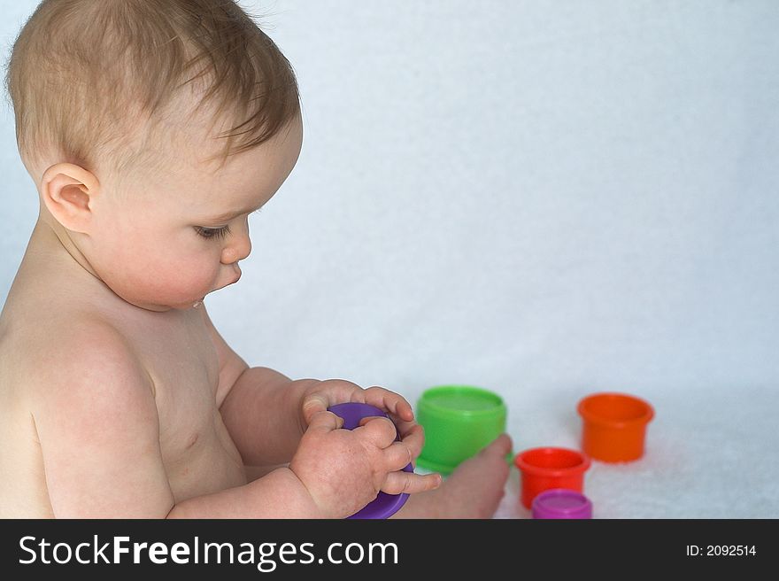 Image of adorable baby playing with stacking cups. Image of adorable baby playing with stacking cups