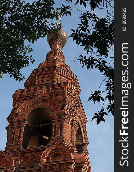 Orthodox brick church between tree leaves. Orthodox brick church between tree leaves