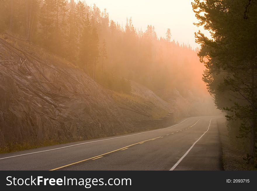 The sun rises over a roadway in Yellowstone national park. The sun rises over a roadway in Yellowstone national park