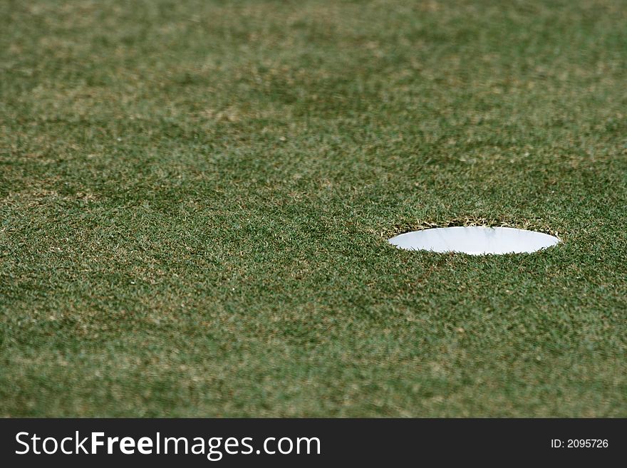 A close up of hole in the golf field.