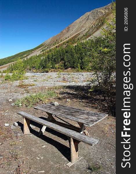 Bench, table and mountainside. Altay. Russia.