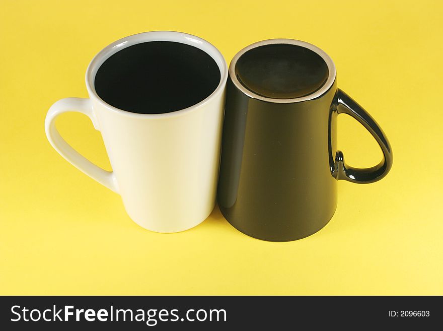 Black and white cups on yellow