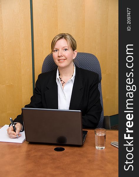 Businesswoman in a board room with his grey laptop. Businesswoman in a board room with his grey laptop