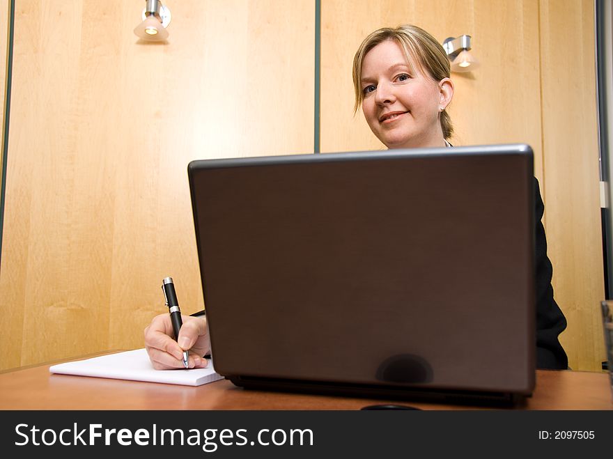 Businesswoman in a board room with his grey laptop. Businesswoman in a board room with his grey laptop