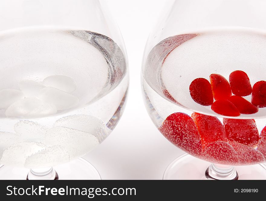 Two glasses with pebbles resembling white and red wine