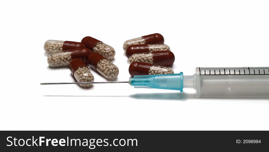 Close-up of syringe and tablets isolated on white. Close-up of syringe and tablets isolated on white