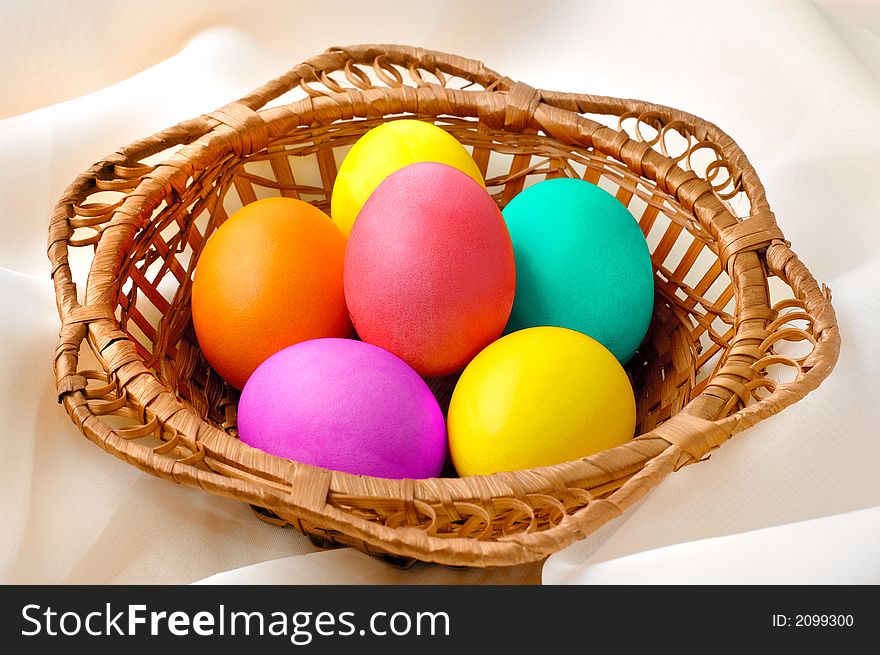 Colorful Easter eggs and a toy chick in a basket still life. Colorful Easter eggs and a toy chick in a basket still life