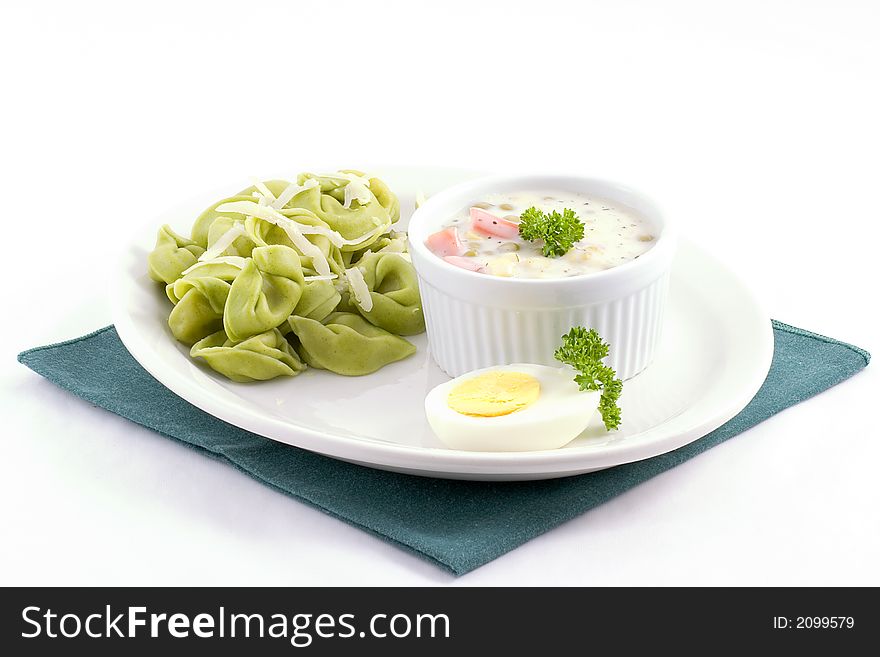 Spinach tortellini filled with cheese and a side of savory dill sauce filled with corn,carrots,and peas, add an egg slice and parsley as garnish and there you go!