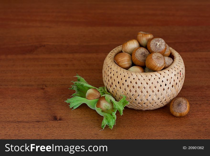 Hazelnuts in a basket over wood background