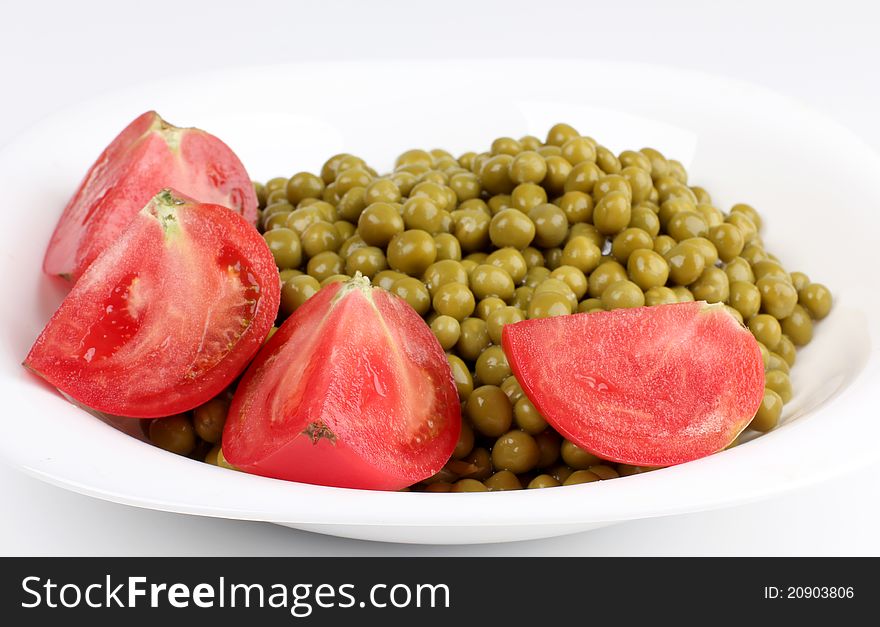 Color photograph of green peas and tomato