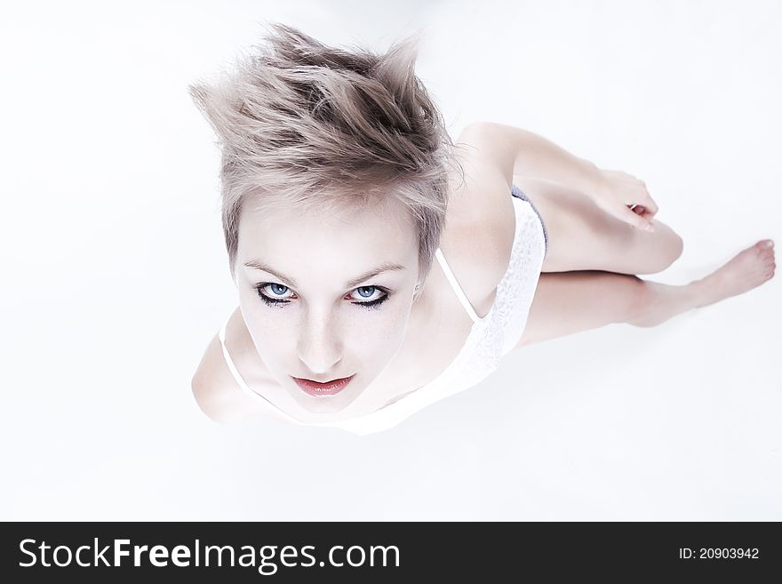 Studio portrait of young beautiful woman with creative haircut looking up