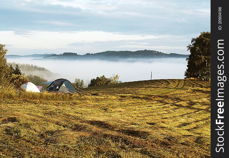 Tents standing in a landscape covered in fog