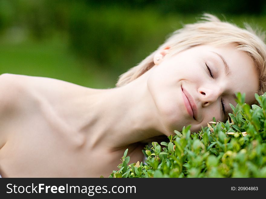 Outdoors portrait of cute young female lying on grass field at the park. Outdoors portrait of cute young female lying on grass field at the park