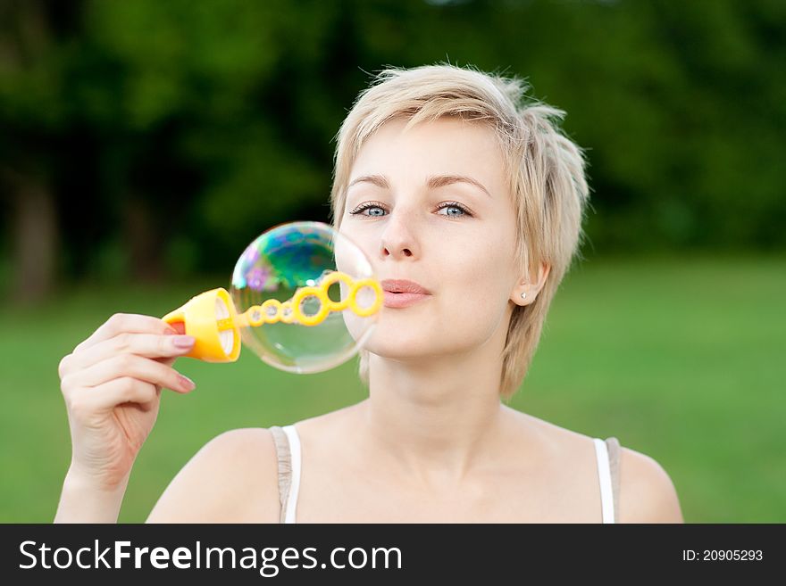 Portrait of young female making soap bubbles. Portrait of young female making soap bubbles