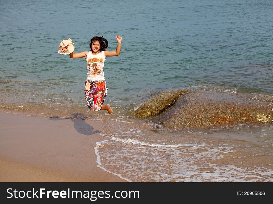 Happy young woman jumping on beach, Thailand