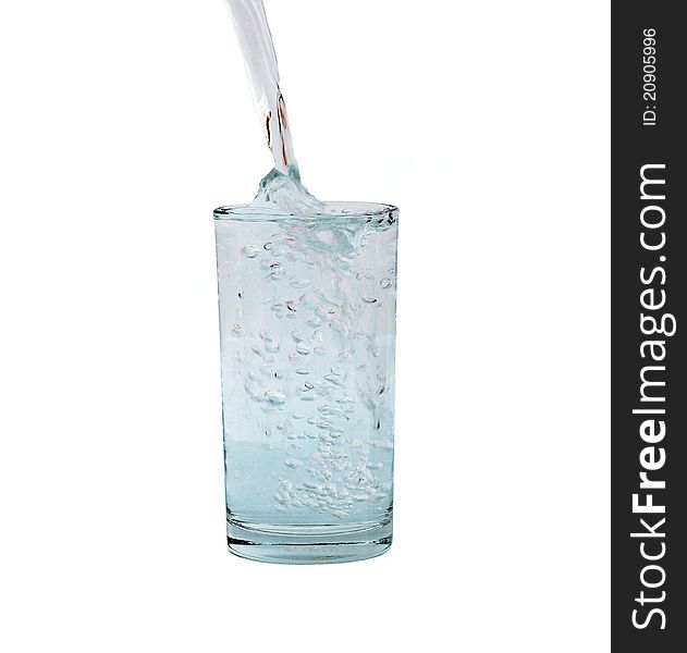 Pouring water in a glass isolated against white background