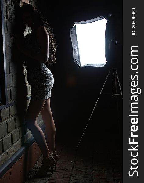 Girl leaning against a wall and a softbox. Girl leaning against a wall and a softbox