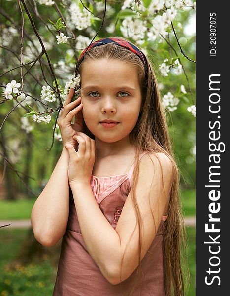 The little girl in a cherry garden