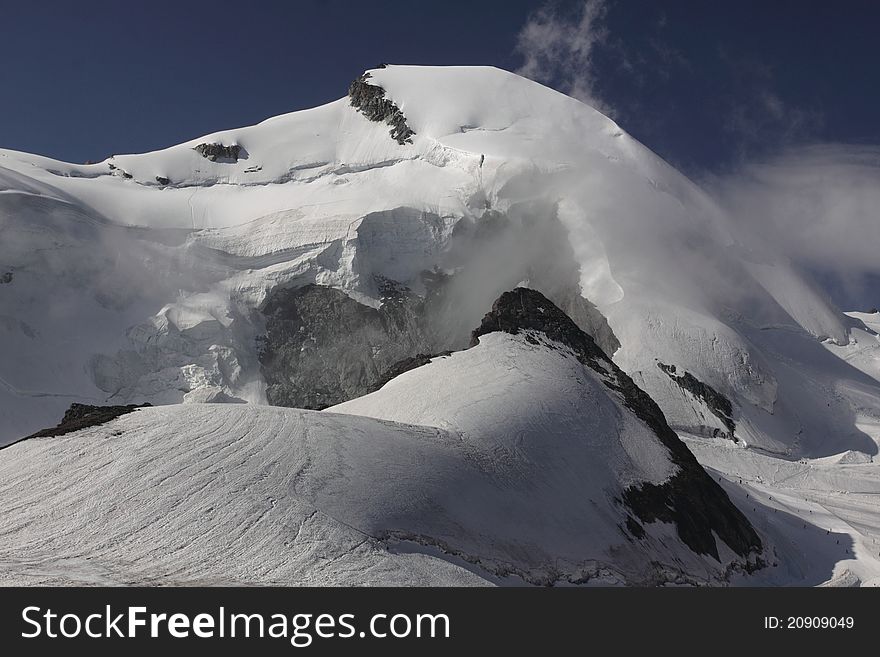 The allalinhorn capped with the mass of snow in Pennine Alps, Switzerland. The allalinhorn capped with the mass of snow in Pennine Alps, Switzerland.