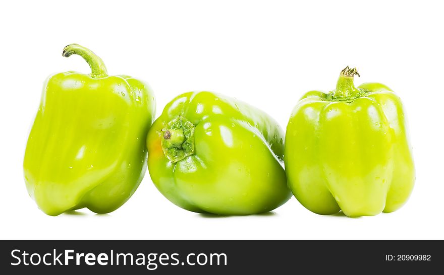 Three sweet green peppers over white background