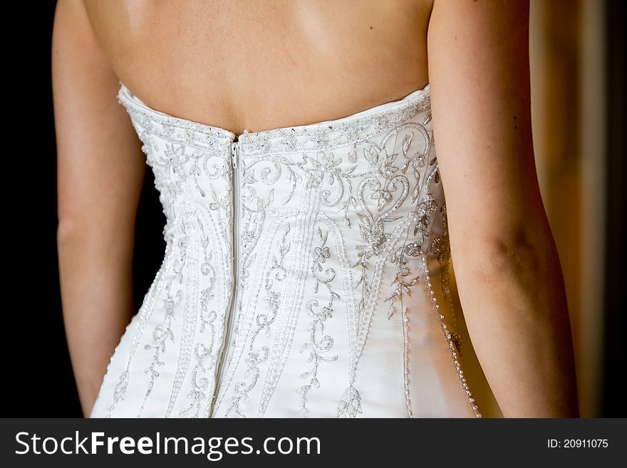 A close up of a caucasian bride's wedding dress at the back. A close up of a caucasian bride's wedding dress at the back