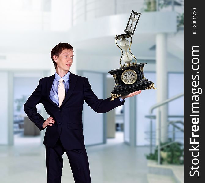 Businessman in office holding clock pyramid