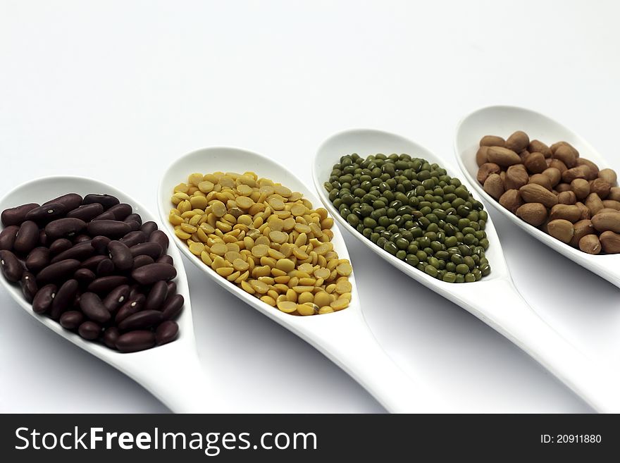 Red bean, mung beans, Peanut, Soybean in ladle on a white background.