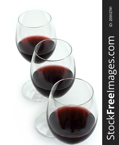 Three glasses of red wine on a white background.