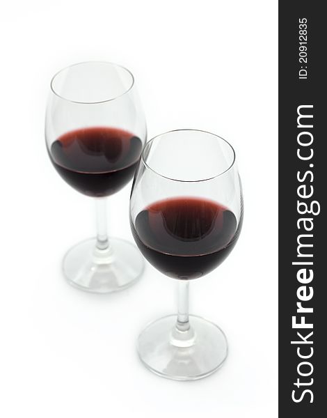 Two glasses of red wine on a white background.