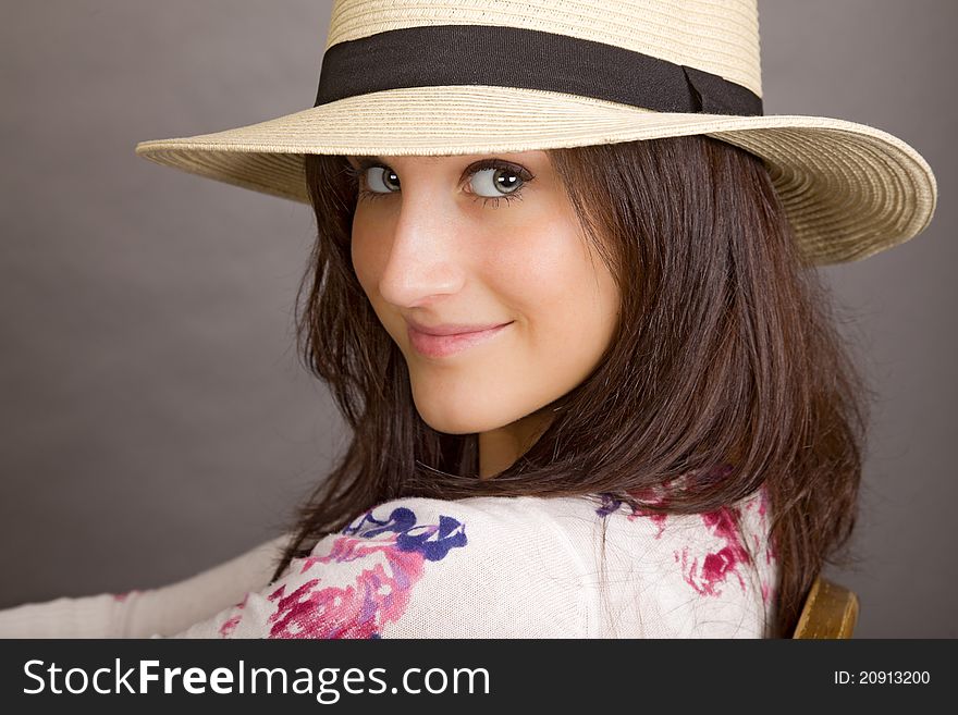 An attractive young woman wearing a white hat with a black band. An attractive young woman wearing a white hat with a black band