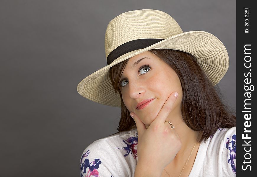 An attractive young woman wearing a white hat, pondering. An attractive young woman wearing a white hat, pondering