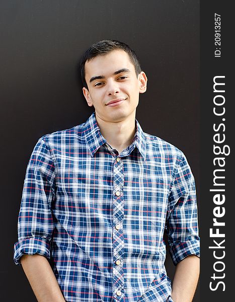 Portrait of handsome young man leaning casual on wall outside. Portrait of handsome young man leaning casual on wall outside