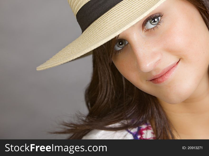 An attractive young woman wearing a white hat with a black band. An attractive young woman wearing a white hat with a black band