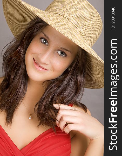 A beautifaul brunette woman wearing a red dress and a wide brim straw hat. A beautifaul brunette woman wearing a red dress and a wide brim straw hat