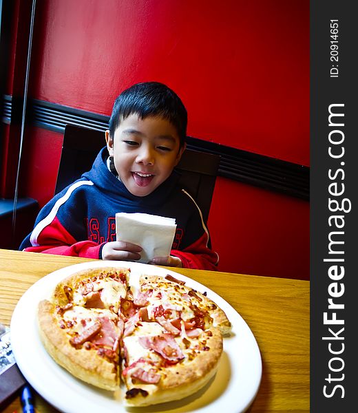 Asian Boy ready to eat a pizza with Happy and Enjoy. Asian Boy ready to eat a pizza with Happy and Enjoy
