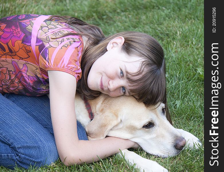 Preteen girl smiling and hugging a yellow labrador. Preteen girl smiling and hugging a yellow labrador