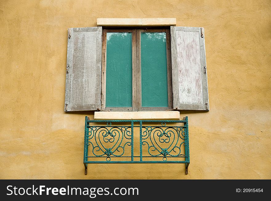 Old wooden window on yellow wall