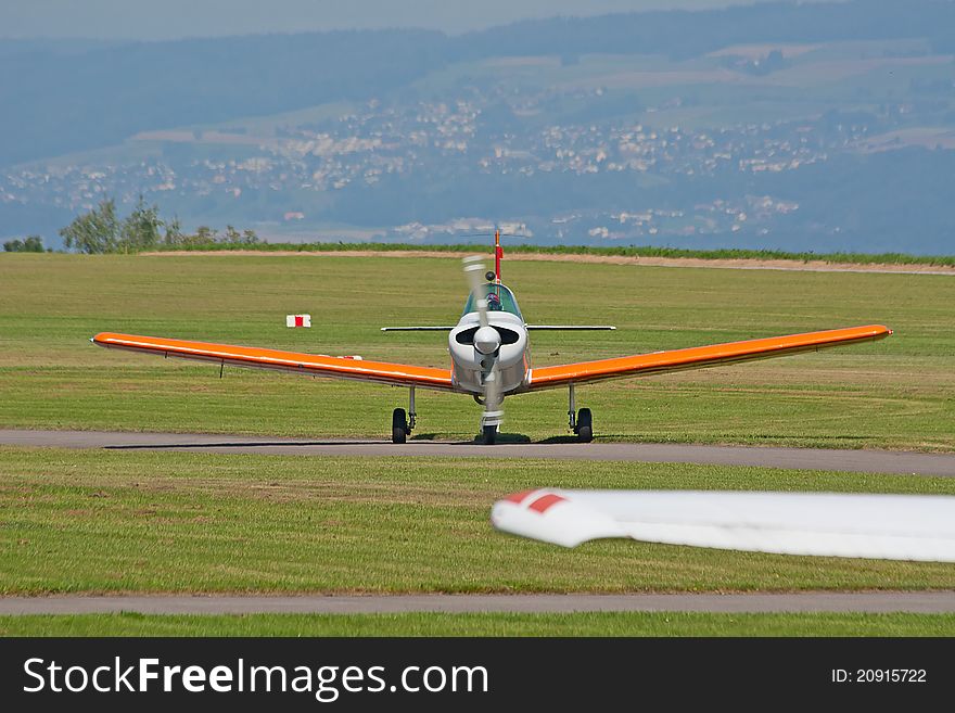Small ariplane on the ground near hangar