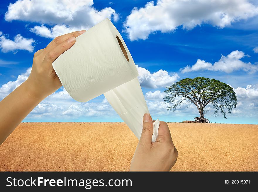 Hand holding tissue paper in tree and desert background