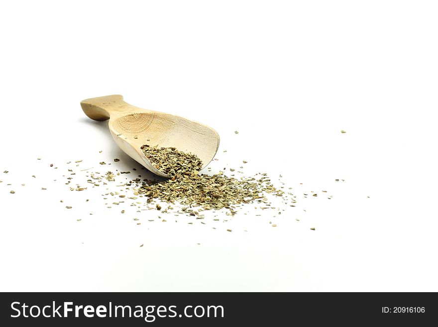 A wooden spoon with basil is isolated
