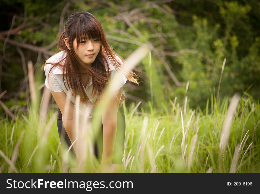 Young Thai woman seeking for something in the forest