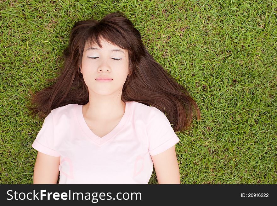 Beautiful Asian girl lying on the green grass field, enjoying with beautiful nature. Beautiful Asian girl lying on the green grass field, enjoying with beautiful nature