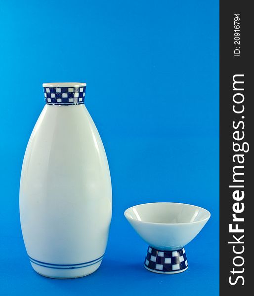 Sake cup and pitcher on blue background