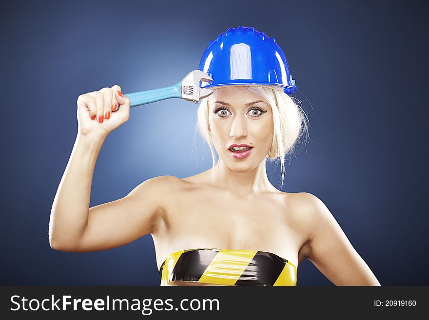 Beautiful blonde with helmet and wrench